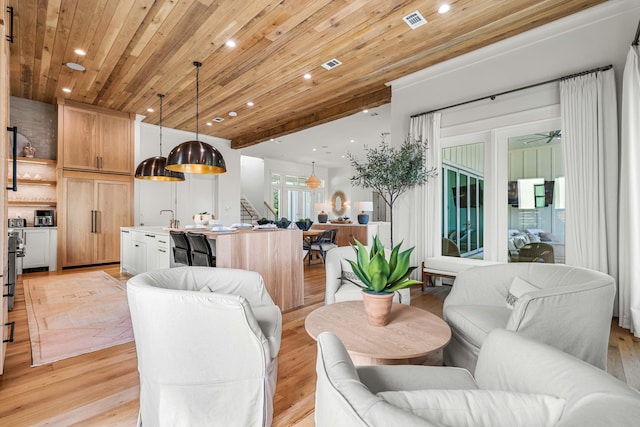 living room with stairway, wooden ceiling, visible vents, and light wood-style floors