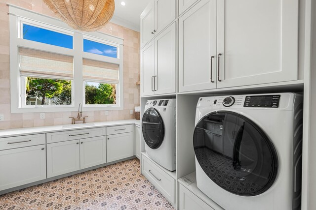 washroom with separate washer and dryer, a sink, cabinet space, and recessed lighting