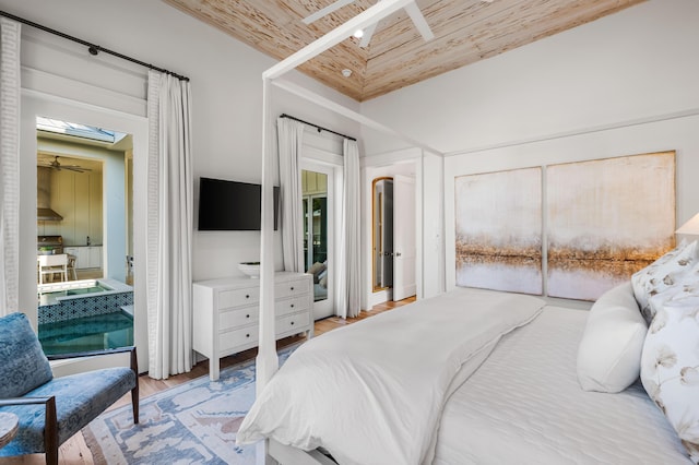 bedroom featuring a skylight, wooden ceiling, a high ceiling, and wood finished floors