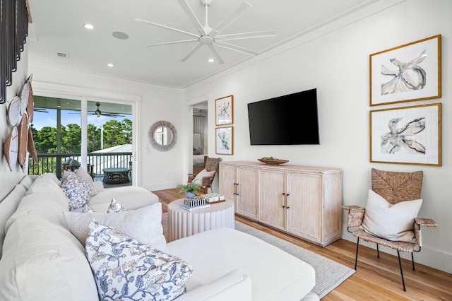 living room with crown molding, recessed lighting, a ceiling fan, light wood-type flooring, and baseboards