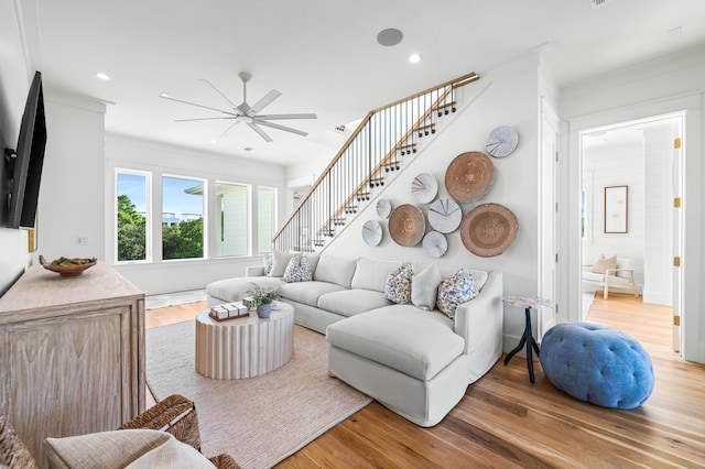 living room with ornamental molding, light wood-type flooring, stairway, and recessed lighting