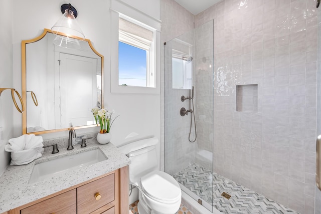 bathroom featuring tiled shower, vanity, and toilet