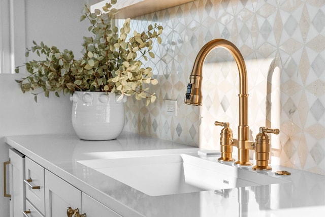 room details featuring white cabinets, light countertops, and a sink