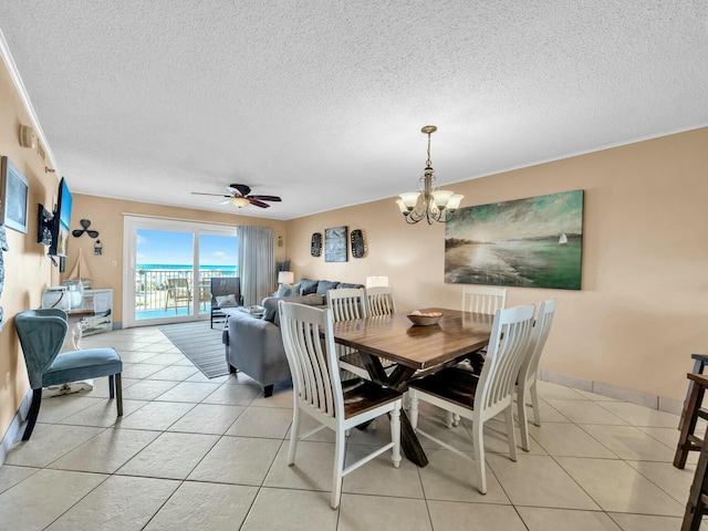 dining space with baseboards, ceiling fan with notable chandelier, a textured ceiling, and light tile patterned flooring