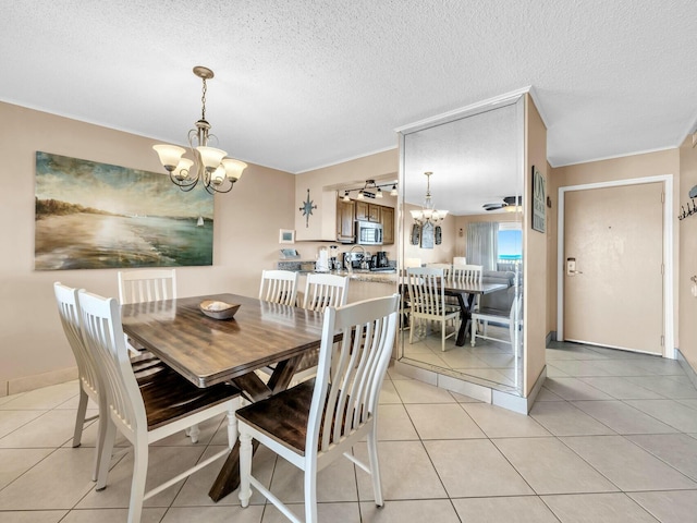 dining area featuring ceiling fan with notable chandelier, a textured ceiling, and light tile patterned floors