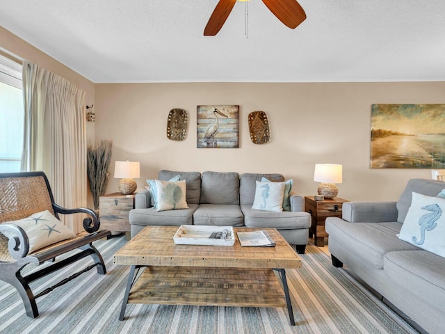 living room featuring ceiling fan and a textured ceiling