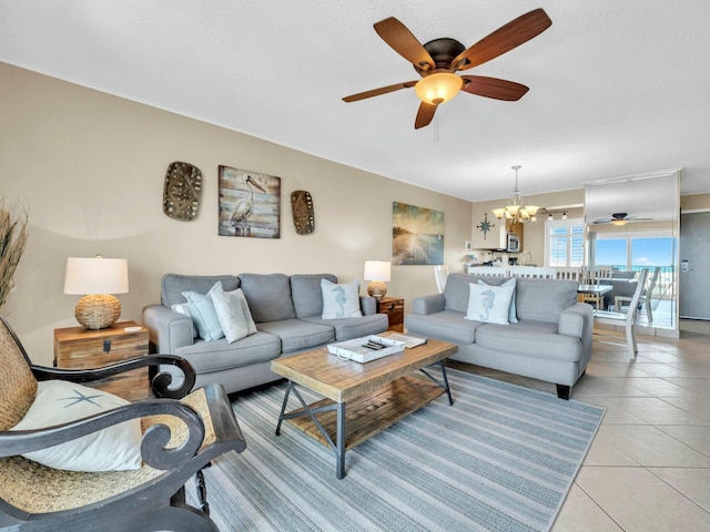 living area with ceiling fan with notable chandelier and light tile patterned flooring