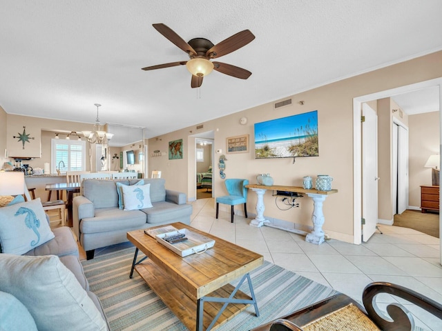 living room featuring light tile patterned floors, ceiling fan with notable chandelier, visible vents, and baseboards