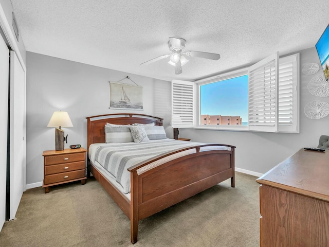 bedroom featuring a textured ceiling, carpet, a ceiling fan, and baseboards