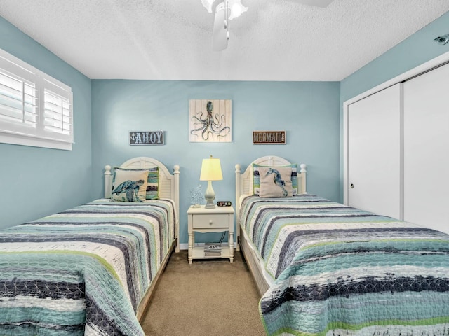 carpeted bedroom featuring a textured ceiling and a ceiling fan