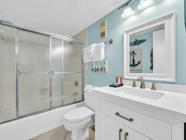 bathroom with toilet, shower / bath combination with glass door, tile patterned flooring, a textured ceiling, and vanity