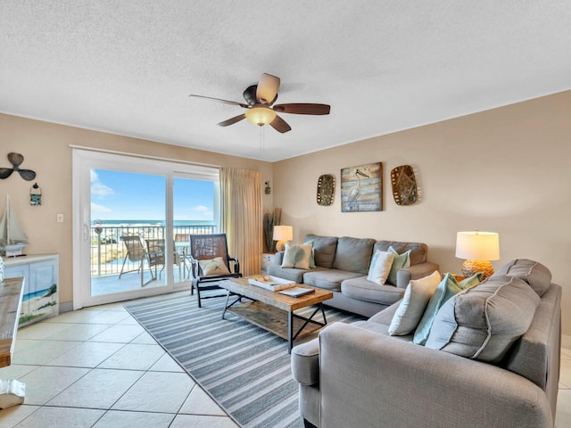 living area featuring ceiling fan, a textured ceiling, and light tile patterned floors