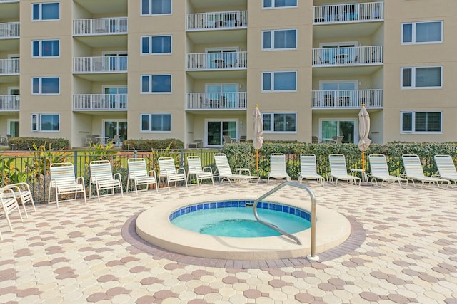 view of swimming pool featuring a hot tub