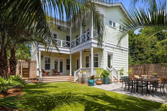 rear view of house featuring french doors, a yard, ceiling fan, a balcony, and fence