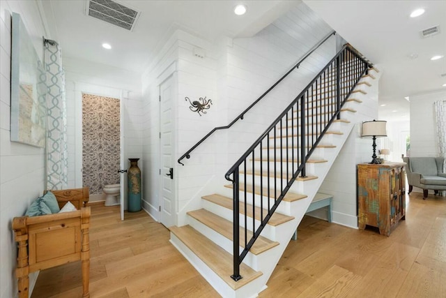 stairway with visible vents, wood finished floors, and recessed lighting