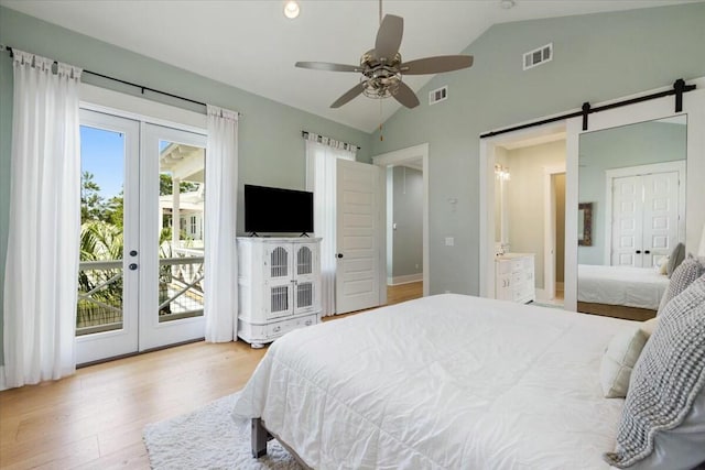 bedroom featuring lofted ceiling, a barn door, visible vents, access to exterior, and french doors