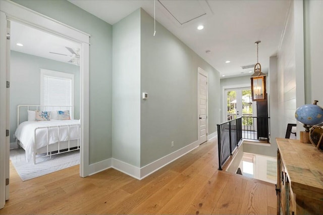 hall featuring baseboards, recessed lighting, attic access, and light wood-style floors