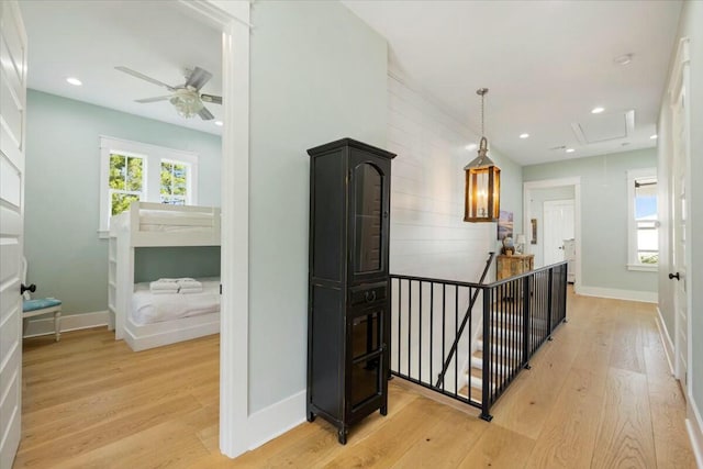 hall with recessed lighting, light wood finished floors, and an upstairs landing