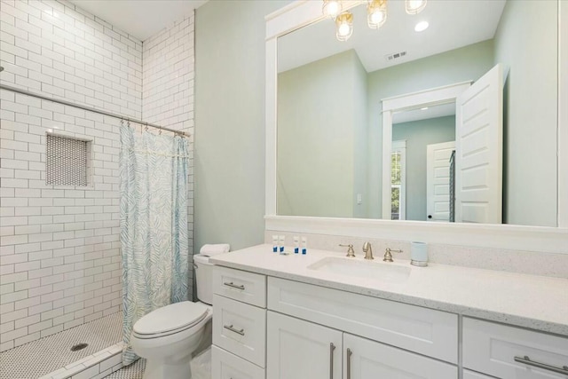 bathroom featuring toilet, a stall shower, visible vents, and vanity