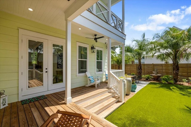 wooden deck with a yard, ceiling fan, fence, and french doors