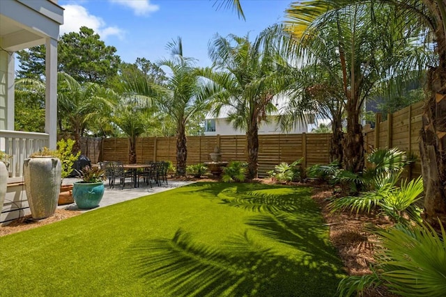 view of yard featuring fence and a patio