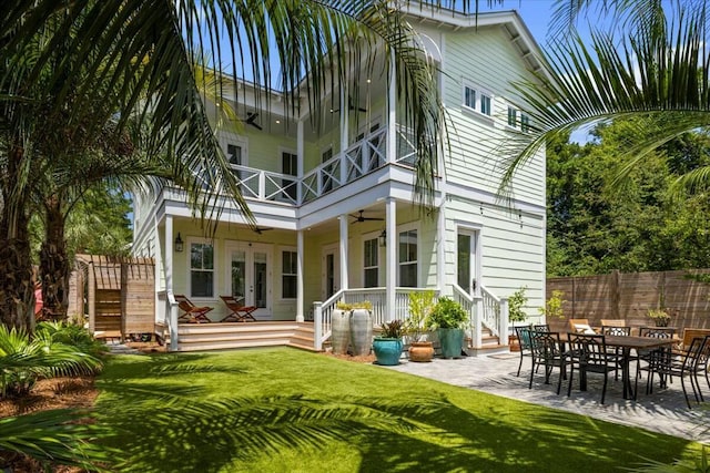 back of house featuring ceiling fan, a balcony, fence, a yard, and french doors