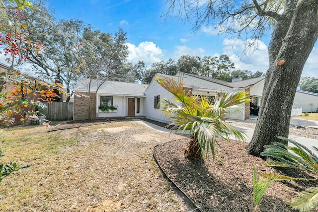 view of front of property featuring driveway and fence