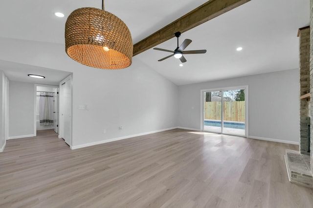 unfurnished living room featuring baseboards, lofted ceiling with beams, ceiling fan with notable chandelier, a fireplace, and light wood-style floors