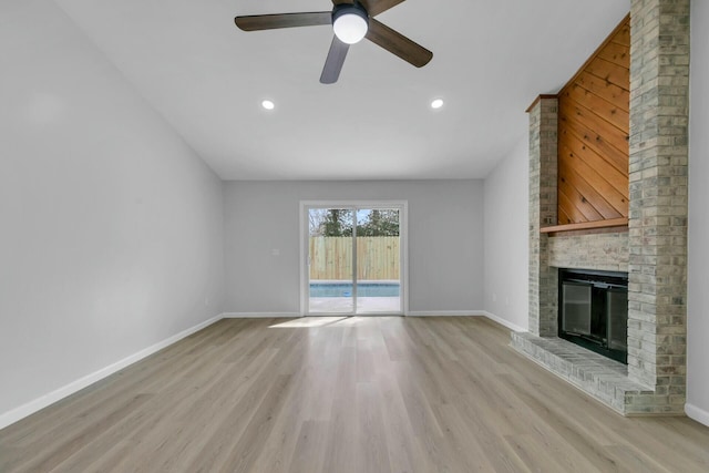 unfurnished living room featuring recessed lighting, a fireplace, baseboards, and light wood finished floors