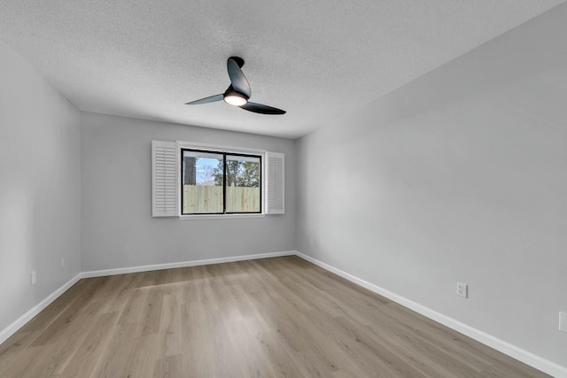 empty room with light wood-style flooring, a textured ceiling, baseboards, and ceiling fan