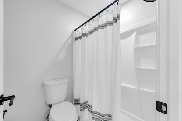 bathroom with toilet and a shower with curtain