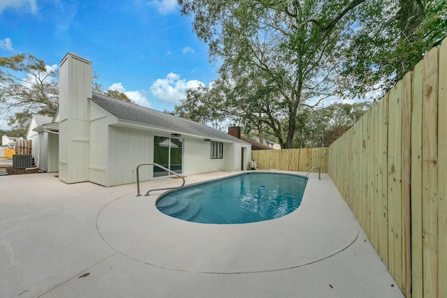 view of pool featuring cooling unit, a fenced in pool, a fenced backyard, and a patio area