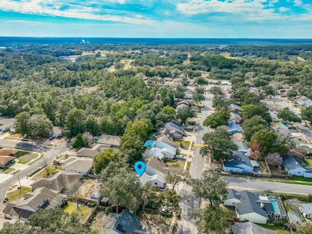 birds eye view of property featuring a residential view and a wooded view