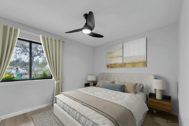 bedroom featuring wood finished floors, baseboards, and ceiling fan