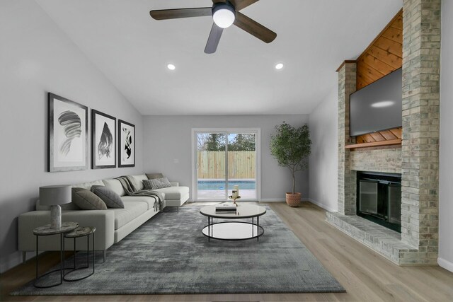 living area with lofted ceiling, wood finished floors, recessed lighting, baseboards, and a brick fireplace