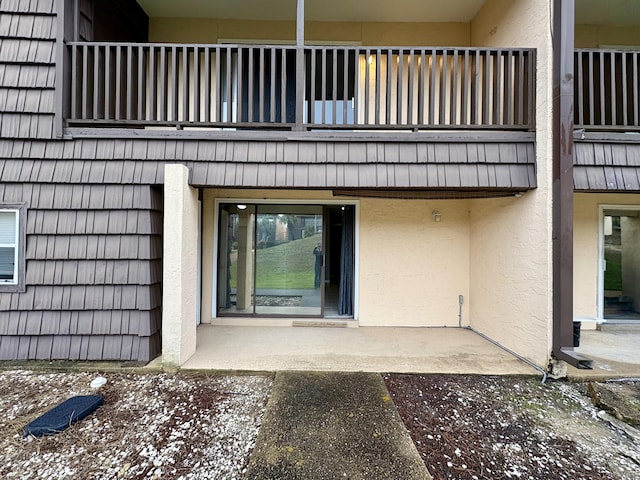 doorway to property featuring a balcony and stucco siding