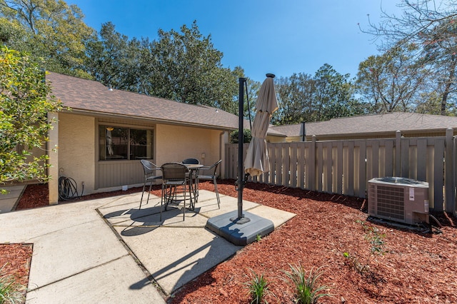 view of patio featuring central air condition unit and fence