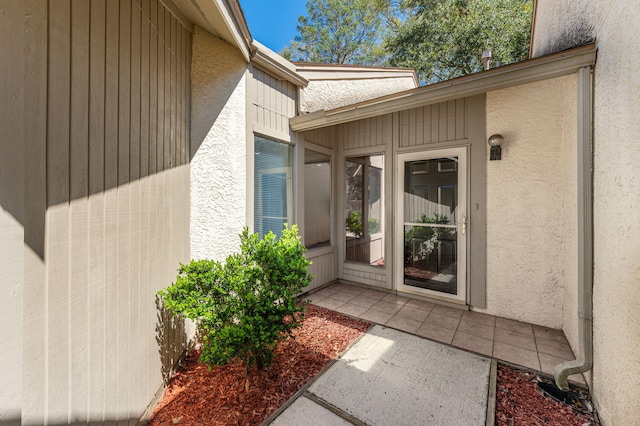 view of exterior entry with a patio area and stucco siding