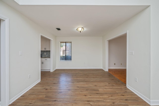 unfurnished room with visible vents, baseboards, and light wood-style floors