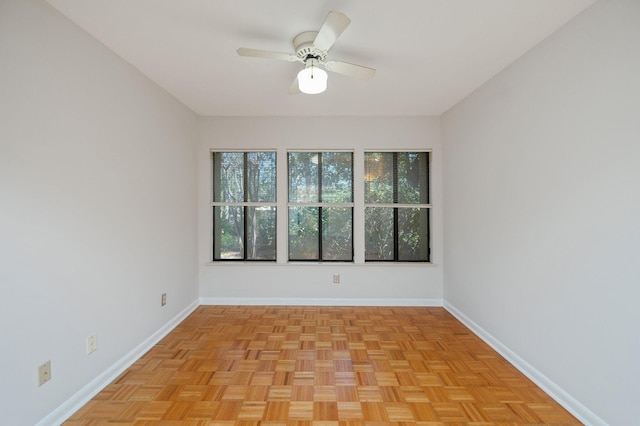 spare room with a ceiling fan and baseboards