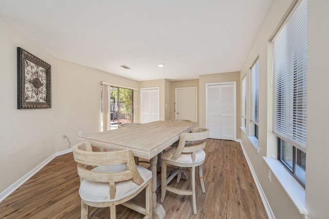 dining space with visible vents, baseboards, and wood finished floors