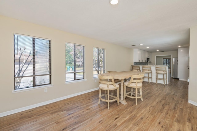 dining space with recessed lighting, baseboards, and light wood finished floors