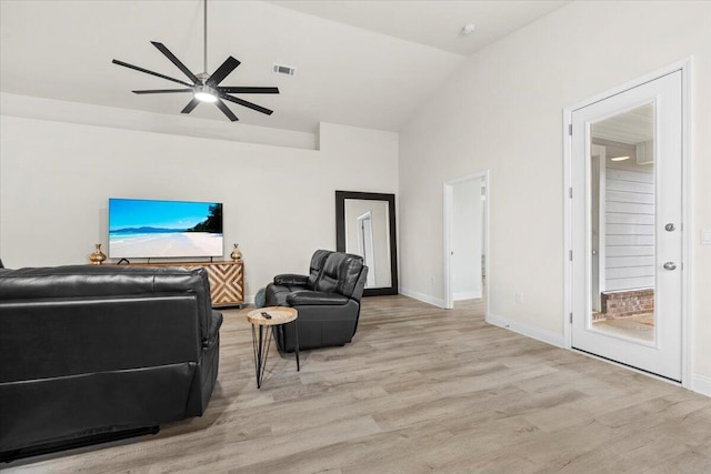 interior space featuring a ceiling fan, baseboards, visible vents, vaulted ceiling, and light wood-type flooring