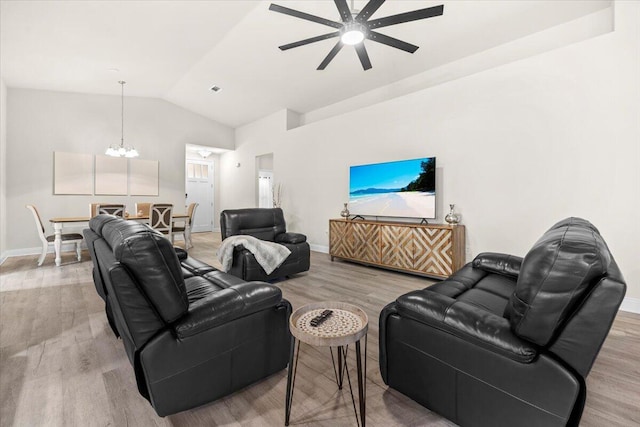 living area featuring light wood-style flooring, baseboards, and vaulted ceiling