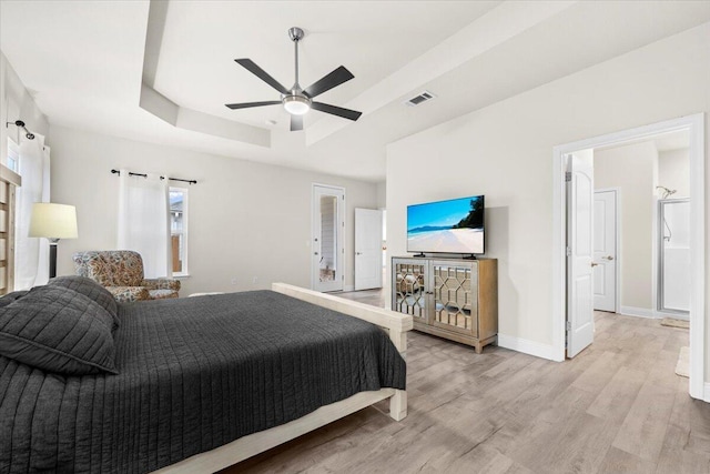 bedroom with visible vents, wood finished floors, baseboards, a raised ceiling, and ceiling fan