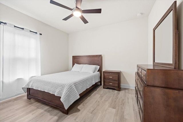 bedroom with baseboards, light wood-type flooring, and ceiling fan