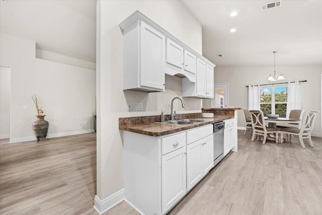 kitchen featuring a sink, dishwasher, white cabinets, and light wood finished floors