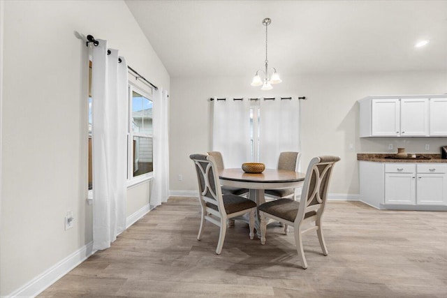 dining area with a notable chandelier, baseboards, and light wood-type flooring