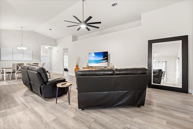 living area with wood finished floors, visible vents, baseboards, high vaulted ceiling, and ceiling fan with notable chandelier