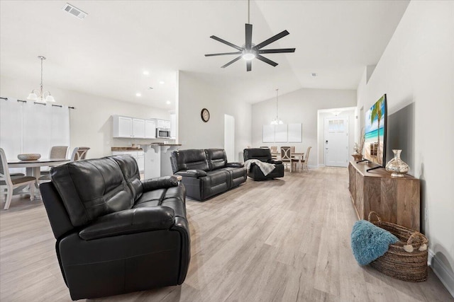 living room featuring visible vents, light wood finished floors, lofted ceiling, recessed lighting, and ceiling fan with notable chandelier